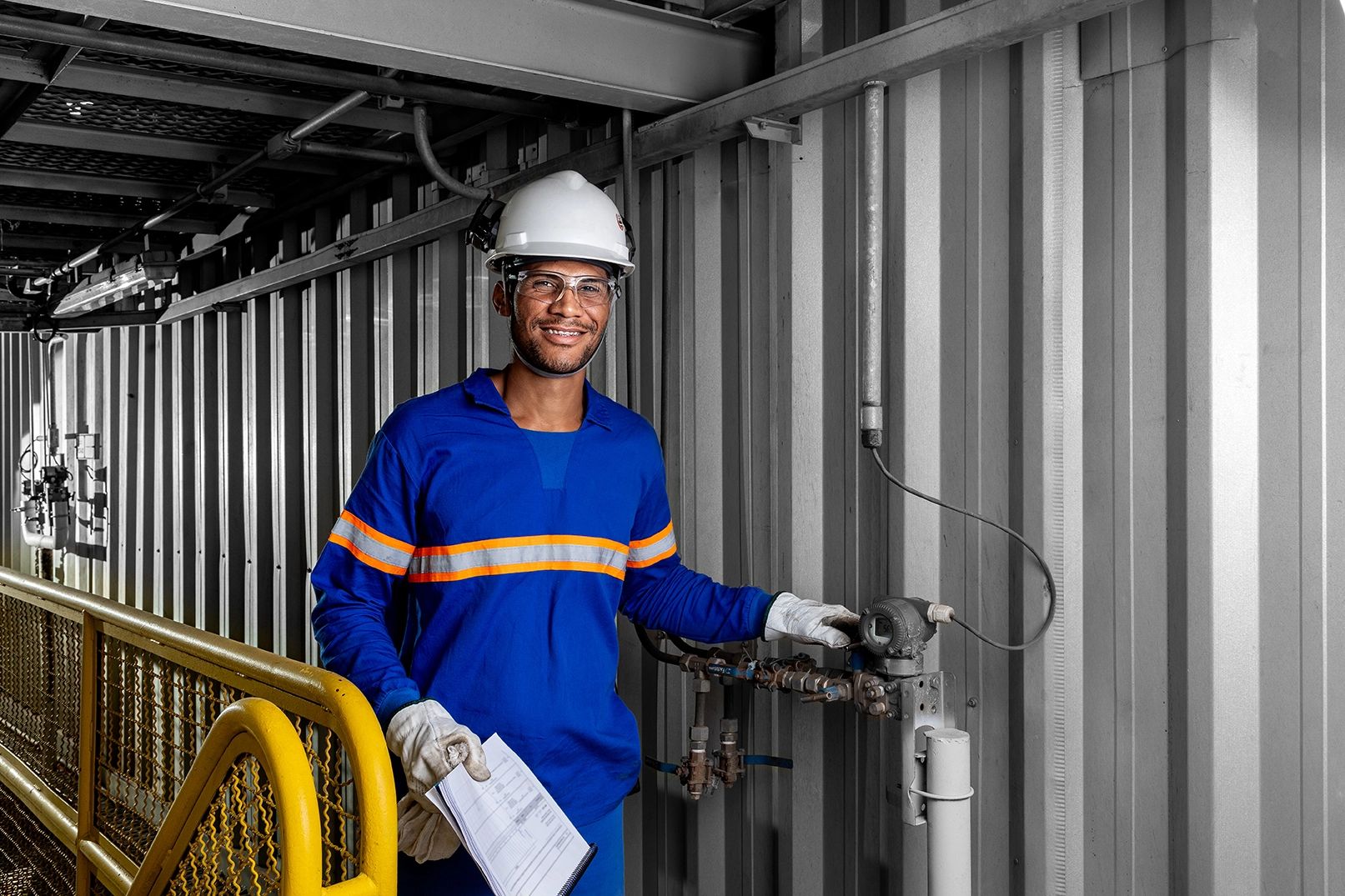 Fotografia industrial — operador na linha de produção de soja — Operador com capacete, óculos, protetor auricular e luvas no painel de controle, na unidade da Bunge em Luís Eduardo Magalhães, Bahia.