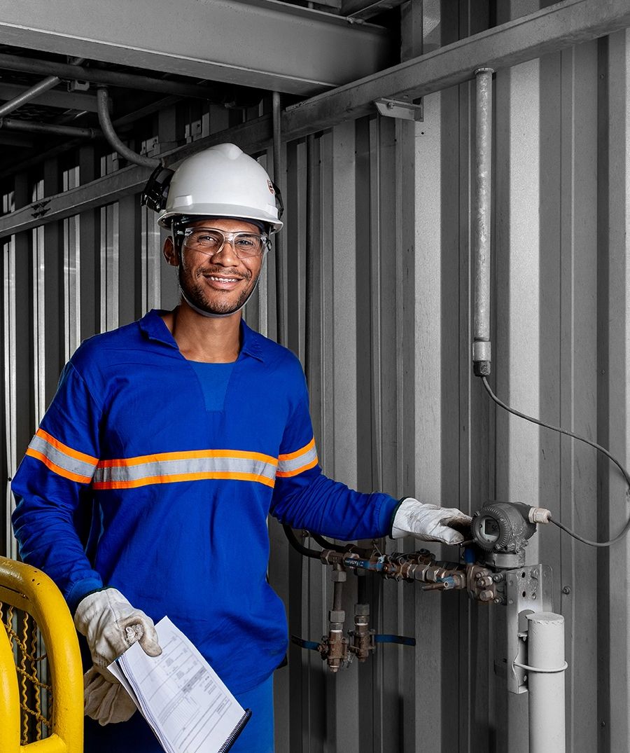 Fotografia industrial — operador na linha de produção de soja — Operador com capacete, óculos, protetor auricular e luvas no painel de controle, na unidade da Bunge em Luís Eduardo Magalhães, Bahia.
