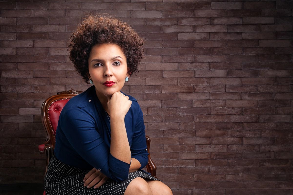 Retrato corporativo feminino em estúdio — Retrato profissional de executiva sentada, com fundo de tijolo, feito em estúdio no Alto da Lapa, São Paulo.